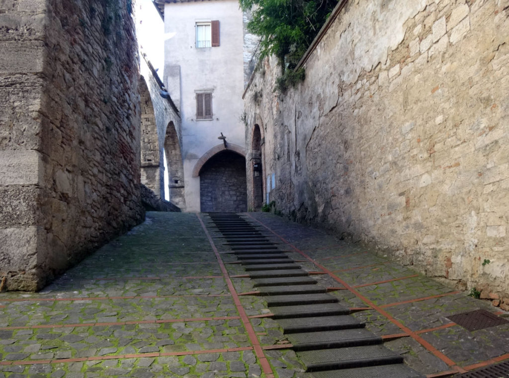 A side street with tiny steps to climb and long, smooth tracks for water to flow downhill. Todi, Italy 2016.