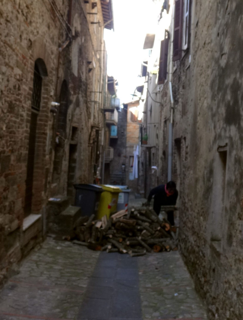 A resident brings in firewood from an alley in Todi, Italy 2016.