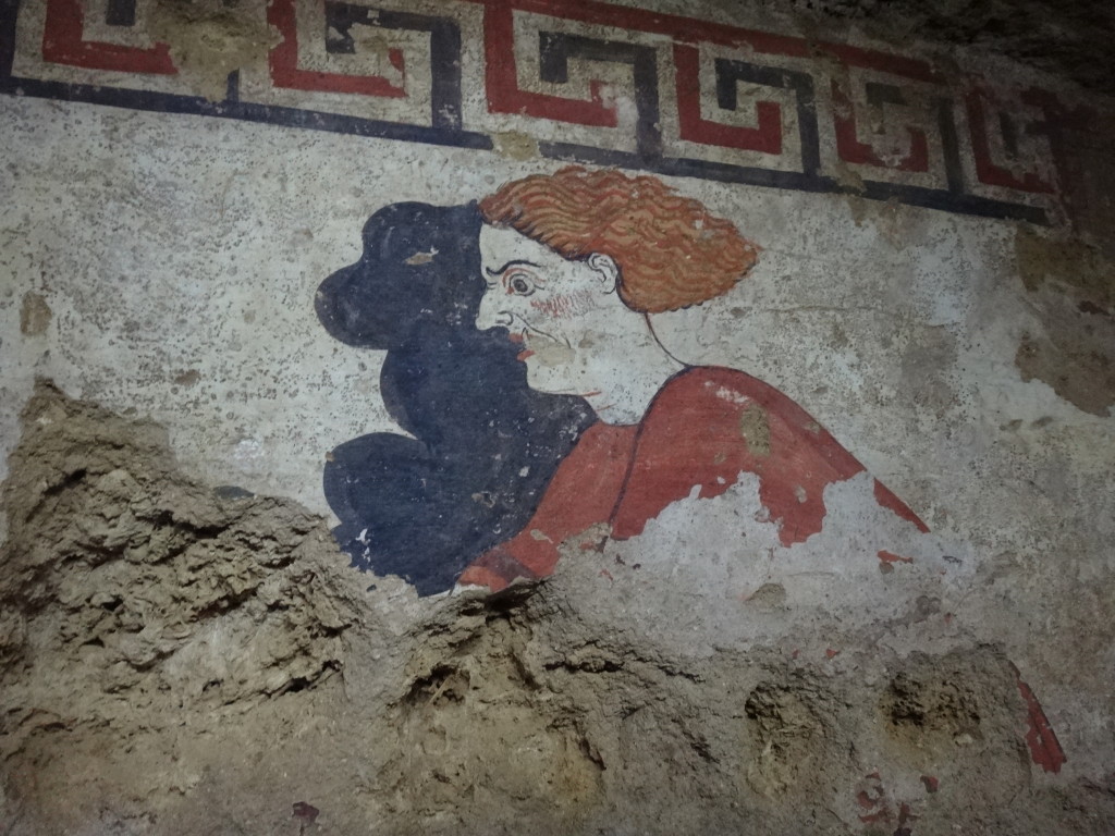 The demon Charon drives the chariot from hell shadowed by a second black demon known in Etruscan stories. This is the only known depiction of Charon as a chariot driver. Museo Civico Archeologico di Sarteano