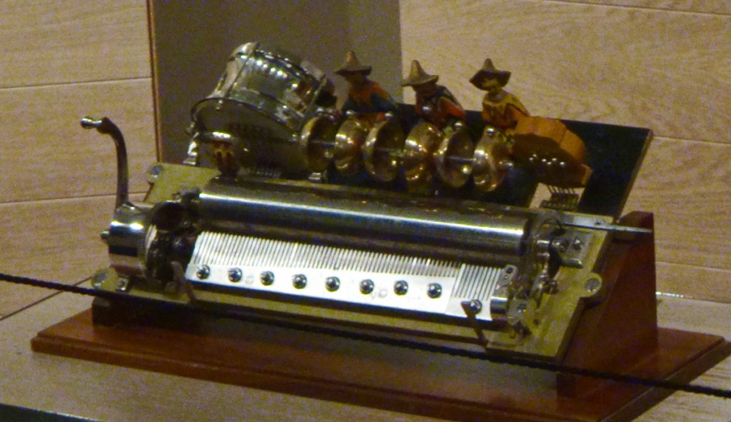 When you turn the handle on this little automaton, the spindles play music and the band members at the top play drums.